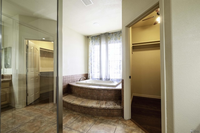14158 E 49th Dr, Yuma, AZ 85367 - full bath with visible vents, a garden tub, tile patterned flooring, a walk in closet, and a ceiling fan