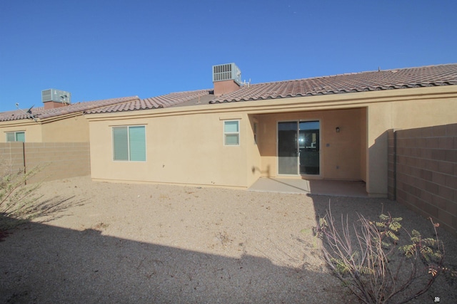 back of house with fence, a patio, stucco siding, and a tile roof