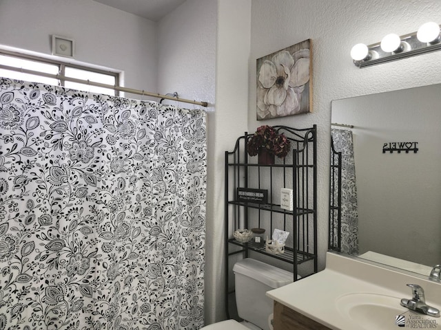 14307 E 49th Ln, Yuma, AZ 85367 - bathroom featuring toilet, a shower with curtain, a textured wall, and vanity