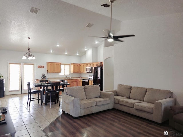 14307 E 49th Ln, Yuma, AZ 85367 - tiled living room featuring visible vents, ceiling fan with notable chandelier, and lofted ceiling