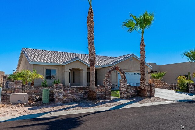 14307 E 49th Ln, Yuma, AZ 85367 - view of front of property featuring driveway, a tile roof, fence private yard, an attached garage, and stucco siding
