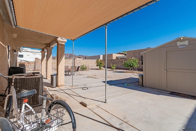 14307 E 49th Ln, Yuma, AZ 85367 - view of patio / terrace featuring outdoor dining area, an outbuilding, central AC unit, a fenced backyard, and a storage unit