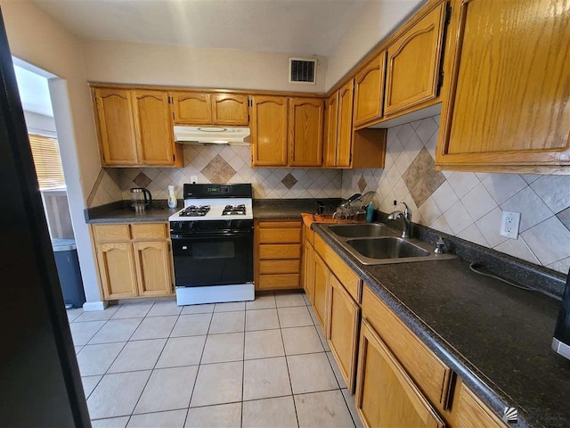 2082 E Ln Mesa St, Yuma, AZ 85365 - kitchen with white gas range oven, under cabinet range hood, decorative backsplash, and dark countertops