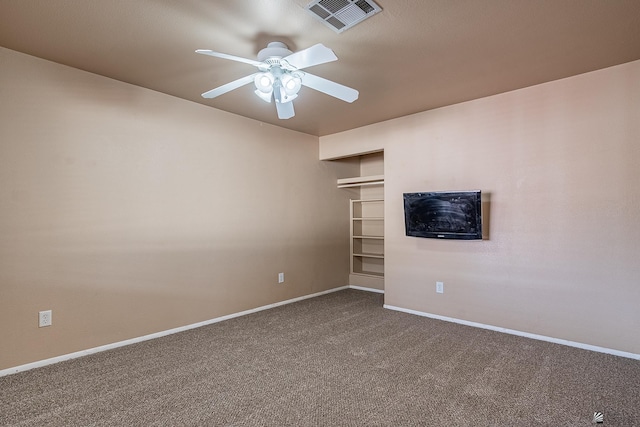 unfurnished room featuring baseboards, ceiling fan, dark colored carpet, and visible vents