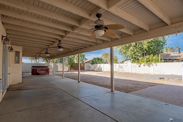 view of patio / terrace with a hot tub, ceiling fan, and a fenced backyard