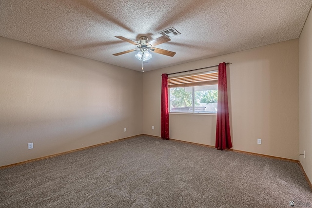 carpeted spare room with baseboards, a ceiling fan, a textured ceiling, and visible vents