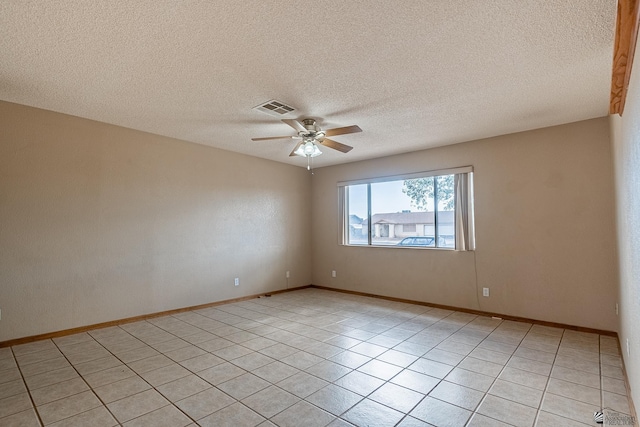 empty room with visible vents, baseboards, ceiling fan, a textured ceiling, and light tile patterned floors