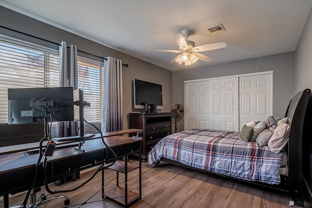 bedroom featuring wood-type flooring, ceiling fan, and a closet