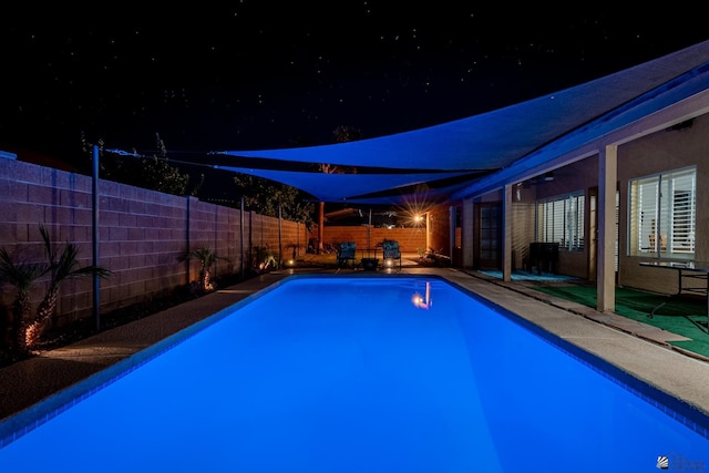 view of pool at twilight