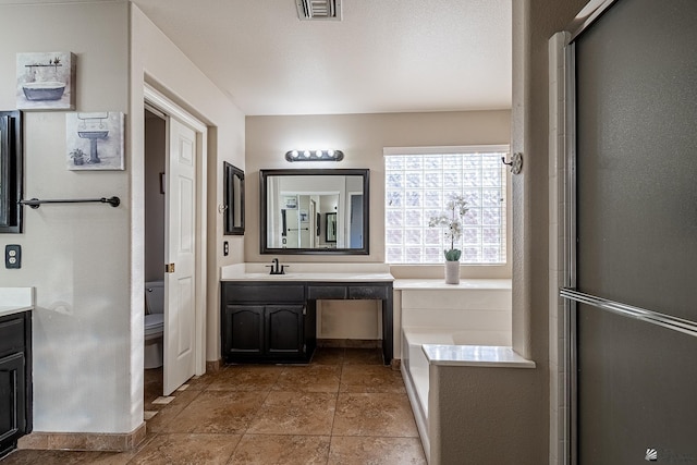 bathroom featuring vanity, toilet, and an enclosed shower