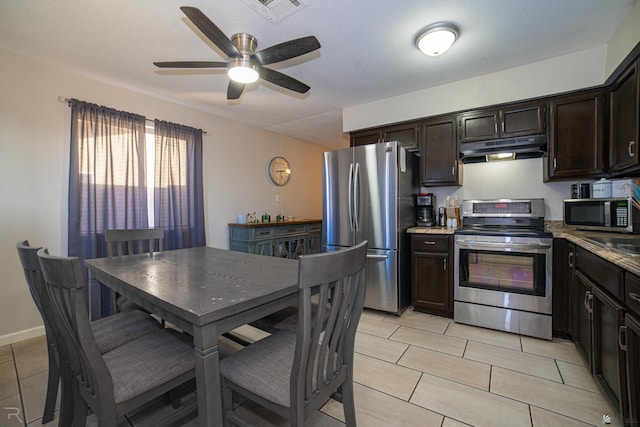 3168 W 31st Ln, Yuma, AZ 85364 - kitchen with stainless steel appliances, under cabinet range hood, dark brown cabinetry, a ceiling fan, and light tile patterned floors