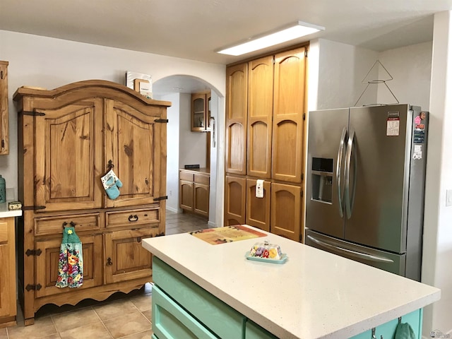 11551 E Via Salida, Yuma, AZ 85367 - kitchen featuring a center island, arched walkways, light countertops, stainless steel fridge with ice dispenser, and light tile patterned floors