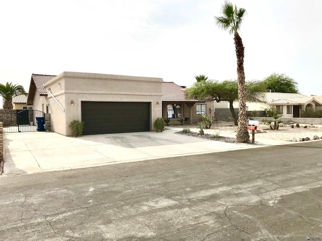 11551 E Via Salida, Yuma, AZ 85367 - view of front of home with a garage, stucco siding, a gate, a tiled roof, and driveway