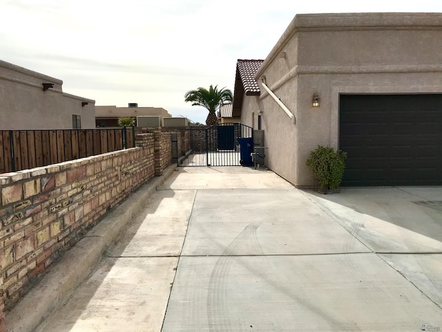 11551 E Via Salida, Yuma, AZ 85367 - view of side of home with a tile roof, a gate, fence, concrete driveway, and stucco siding