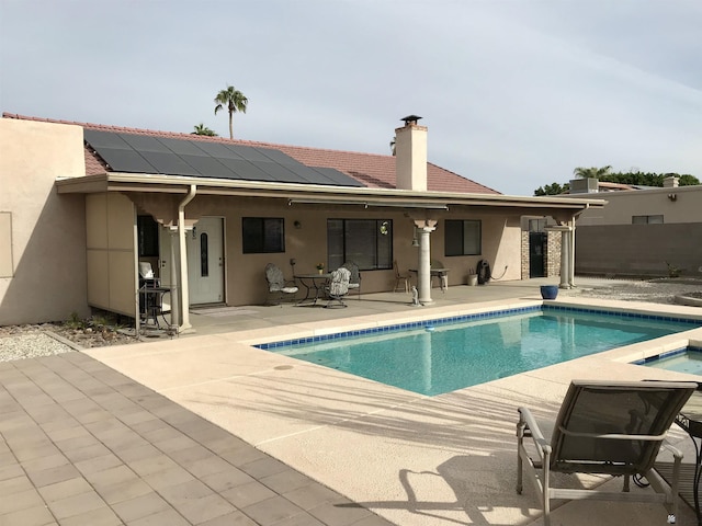 11551 E Via Salida, Yuma, AZ 85367 - rear view of house featuring roof mounted solar panels, a fenced in pool, a patio, and stucco siding