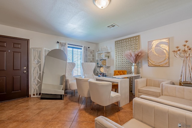 sitting room with visible vents, a textured ceiling, and tile patterned flooring