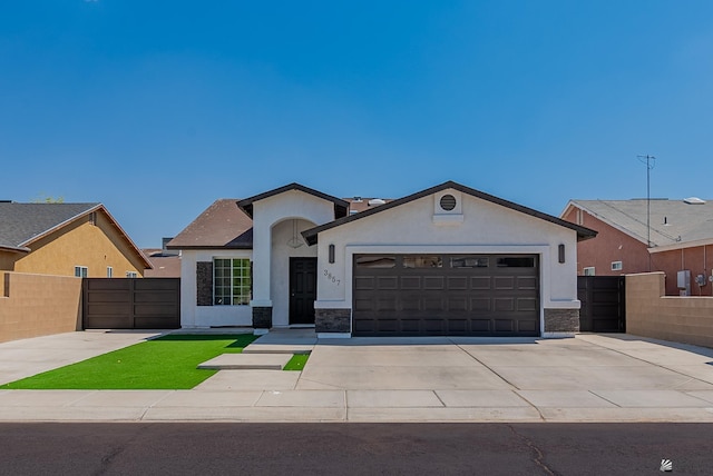 single story home featuring fence, an attached garage, stone siding, stucco siding, and driveway