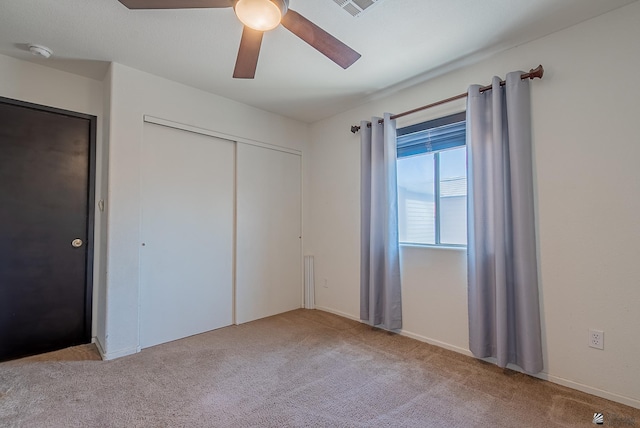 unfurnished bedroom featuring a ceiling fan, carpet, and a closet