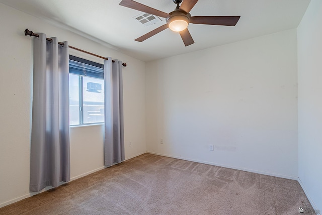 spare room featuring carpet flooring, ceiling fan, visible vents, and baseboards