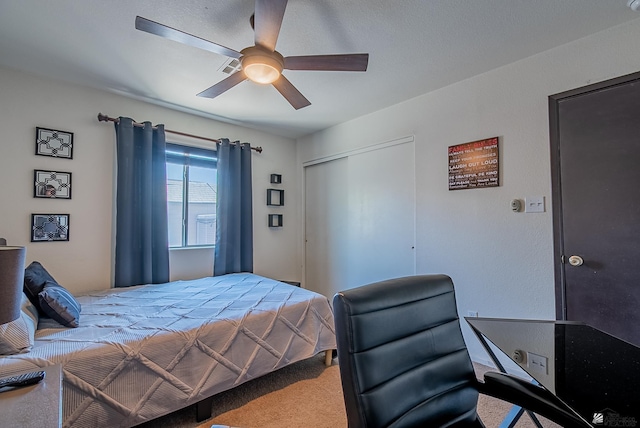 bedroom with a ceiling fan, carpet, and a closet