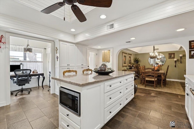 1925 S Ridgeview Dr, Yuma, AZ 85364 - kitchen featuring arched walkways, stainless steel microwave, ceiling fan with notable chandelier, and visible vents