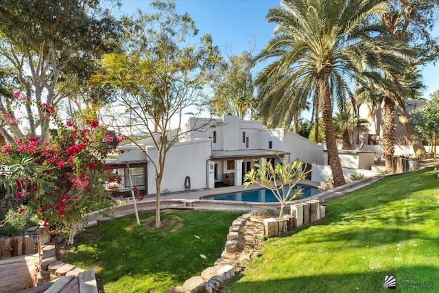 1925 S Ridgeview Dr, Yuma, AZ 85364 - rear view of house with a fenced in pool, stucco siding, and a lawn