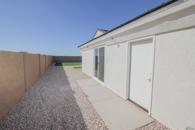 exterior space featuring a fenced backyard and stucco siding
