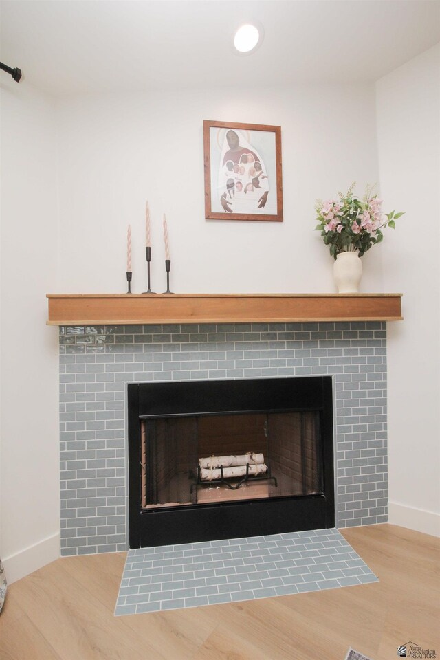 interior details featuring baseboards, a fireplace, and wood finished floors