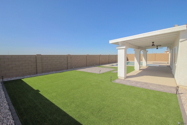 view of yard featuring a patio, ceiling fan, and a fenced backyard