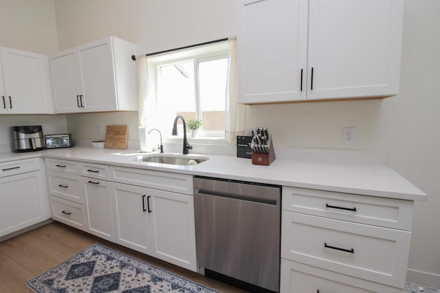 kitchen with a sink, white cabinetry, and dishwasher