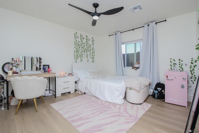 bedroom featuring ceiling fan, visible vents, and light wood-style floors