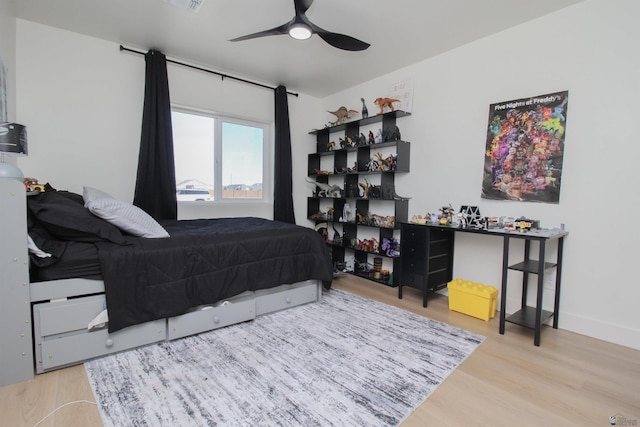 bedroom with visible vents, a ceiling fan, and wood finished floors