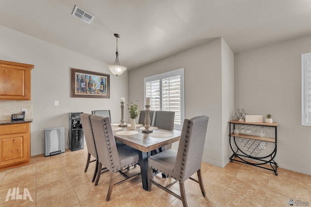 dining room featuring baseboards, vaulted ceiling, and visible vents