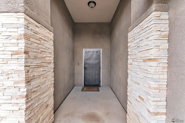 property entrance with stucco siding