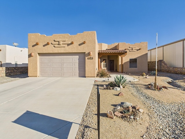 14340 E 49th Ln, Yuma, AZ 85367 - pueblo revival-style home featuring concrete driveway, a garage, a tile roof, and stucco siding