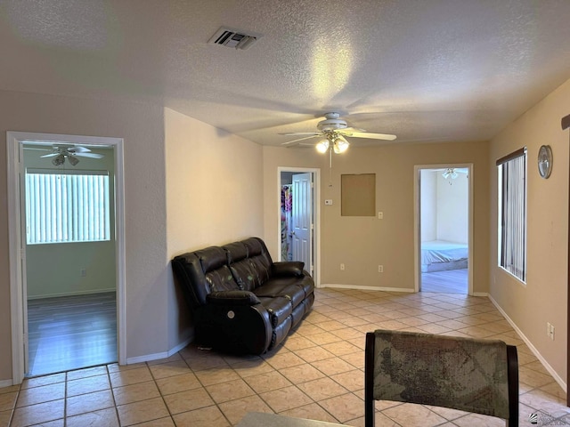 13458 E 53rd Ln, Yuma, AZ 85367 - unfurnished living room with light tile patterned floors, a ceiling fan, a textured ceiling, visible vents, and baseboards