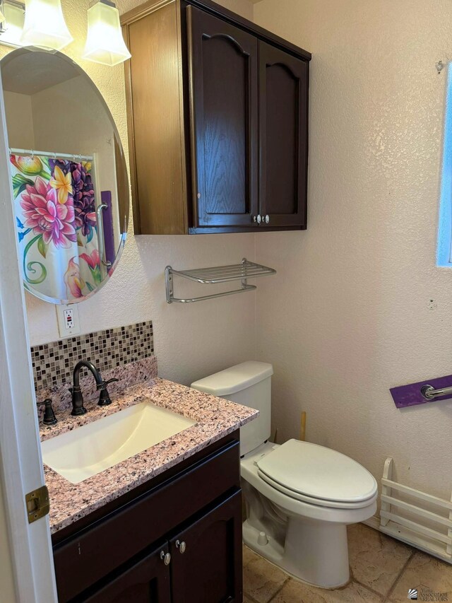 13458 E 53rd Ln, Yuma, AZ 85367 - full bathroom featuring tile patterned floors, toilet, decorative backsplash, and vanity
