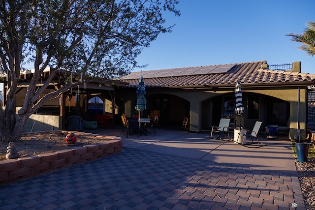 13220 E 55th St, Yuma, AZ 85367 - rear view of house featuring a patio, roof mounted solar panels, a tile roof, and outdoor dining space