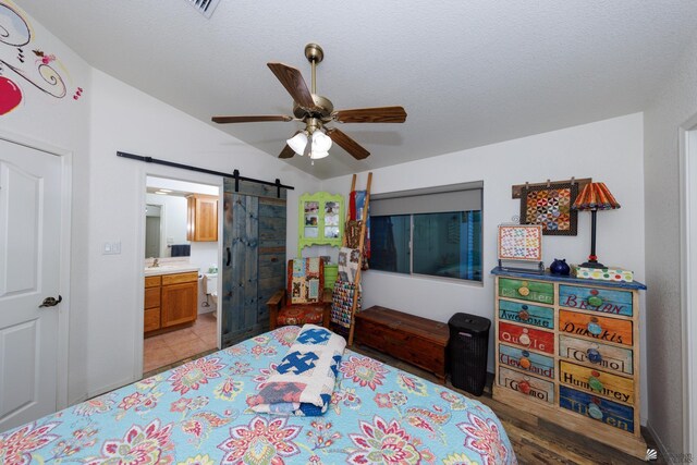13220 E 55th St, Yuma, AZ 85367 - bedroom featuring connected bathroom, ceiling fan, a barn door, a sink, and lofted ceiling