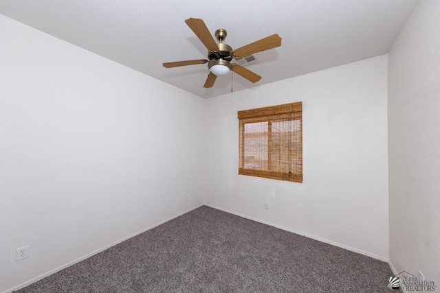 empty room featuring a ceiling fan, baseboards, visible vents, and dark carpet