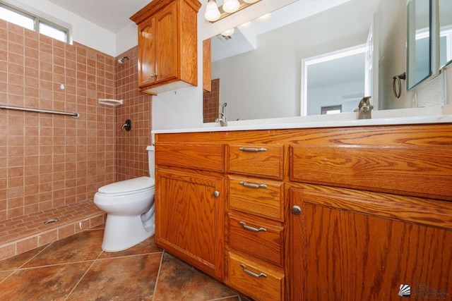full bathroom with vanity, tile patterned floors, a tile shower, and toilet