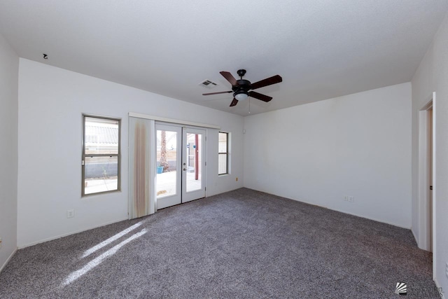 carpeted spare room with a healthy amount of sunlight, a ceiling fan, french doors, and visible vents