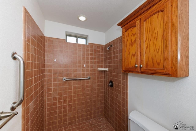 full bathroom featuring toilet and a tile shower