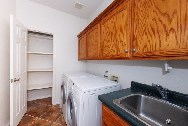 laundry room featuring cabinet space, a sink, separate washer and dryer, dark tile patterned flooring, and visible vents