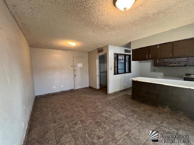2232 W 19th St, Yuma, AZ 85364 - kitchen with a textured ceiling, dark brown cabinetry, and light countertops