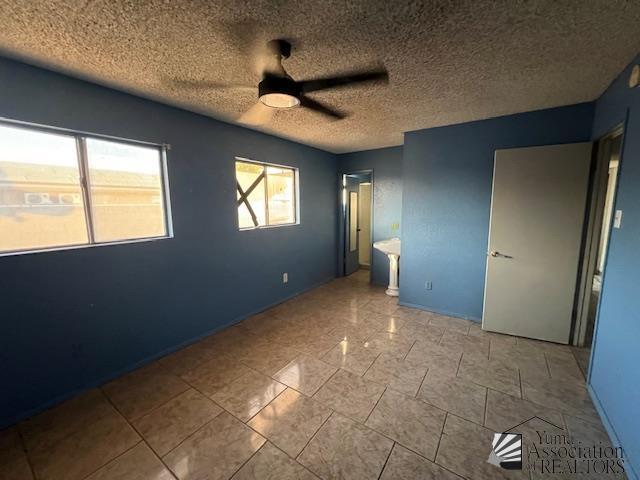 2232 W 19th St, Yuma, AZ 85364 - unfurnished bedroom featuring a textured ceiling and a ceiling fan