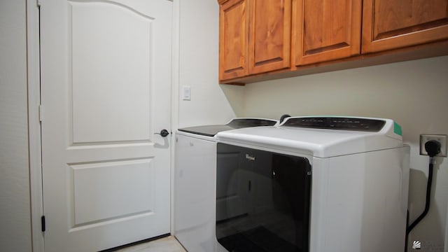 washroom with washer and dryer and cabinet space