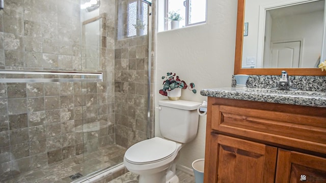 bathroom with vanity, toilet, and a shower stall