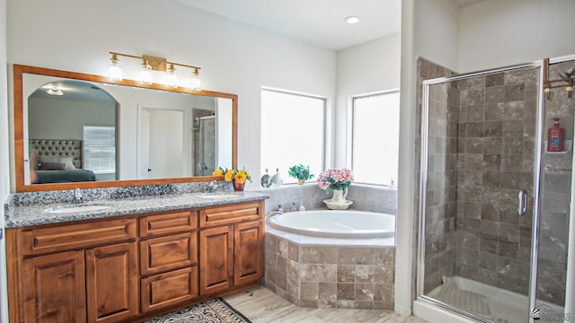 ensuite bathroom featuring connected bathroom, a bath, a stall shower, and a sink