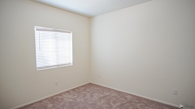 empty room with baseboards and light carpet